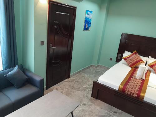 a small bedroom with a bed and a couch at Mazola Diamond Hotel in Dar es Salaam