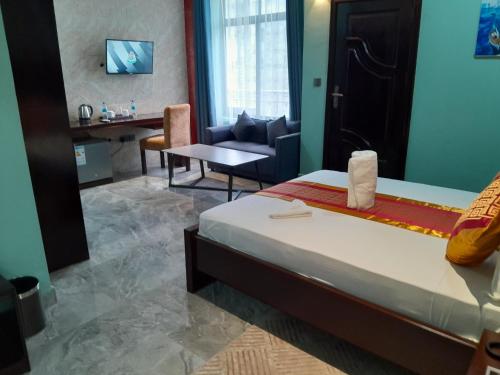 a hotel room with a bed and a living room at Mazola Diamond Hotel in Dar es Salaam