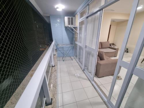 a room with a glass door and a living room at Apto perfeito em Arraial do Cabo - Prainha in Arraial do Cabo