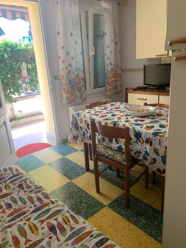 une chambre avec une table et une chaise et une chambre avec une cuisine dans l'établissement Bilocale a trenta metri dal mare, à Roquebrune-Cap-Martin