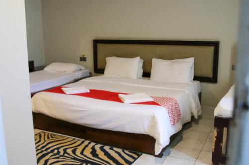 a bedroom with two beds with red and white sheets at The Cinnamon Villa By Kings Bay in Negombo