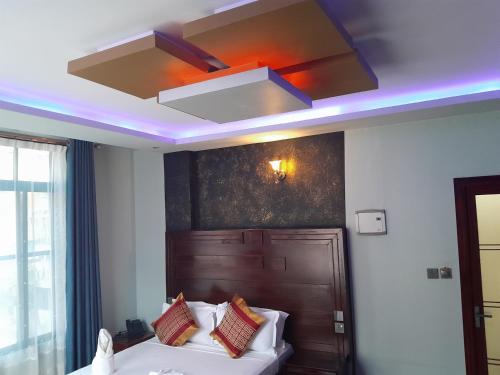 a room with a bed and a ceiling with a light at Mazola Diamond Hotel in Dar es Salaam