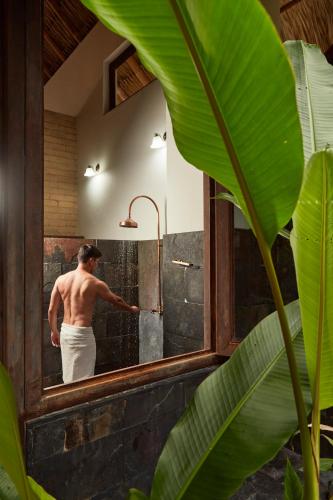 a man standing in a shower in a mirror at Hotel Reserva de Piedemonte in Villavicencio