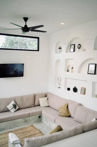 a living room with a couch and a ceiling fan at Villa Cabana Amed in Amed