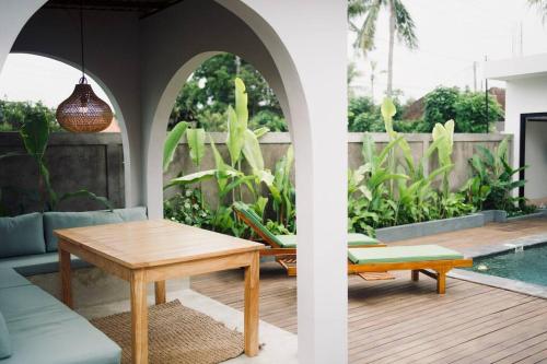 a living room with a table and a pool at Villa Cabana Amed in Amed