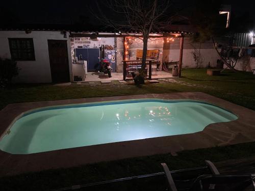 an empty swimming pool at night in a yard at Cabaña con piscina in Atlántida