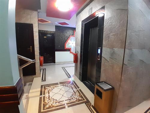 a bathroom with a tile floor with a door and a trash can at Mazola Diamond Hotel in Dar es Salaam