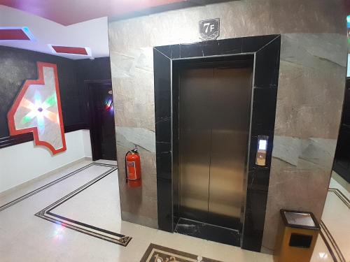 a elevator in a building with a fire extinguisher at Mazola Diamond Hotel in Dar es Salaam