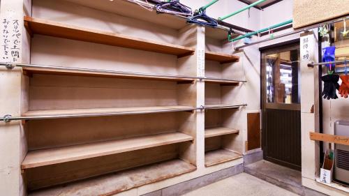 a walk in closet in a building with wooden shelves at 関温泉 吉野屋温泉旅館 in Myoko