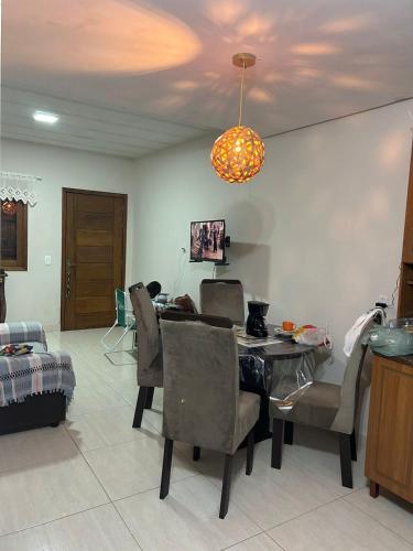 a dining room with a table and chairs and a chandelier at duplex aconchegante in Tramandaí