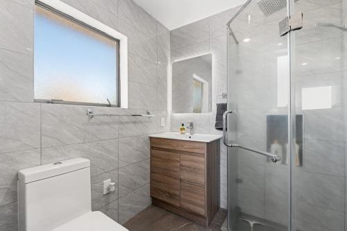 a bathroom with a shower and a toilet and a sink at Lakeview Oasis in Rotorua
