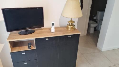 a desk with a television and a lamp on it at Nice San Telmo in Buenos Aires