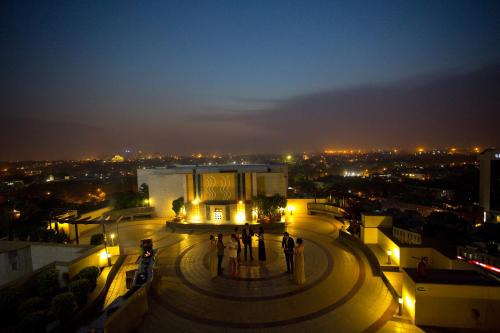 a group of people standing on top of a building at night at The Suryaa New Delhi in New Delhi