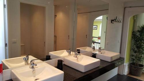 
a bathroom with two sinks and two mirrors at Porto Wine Hostel in Porto
