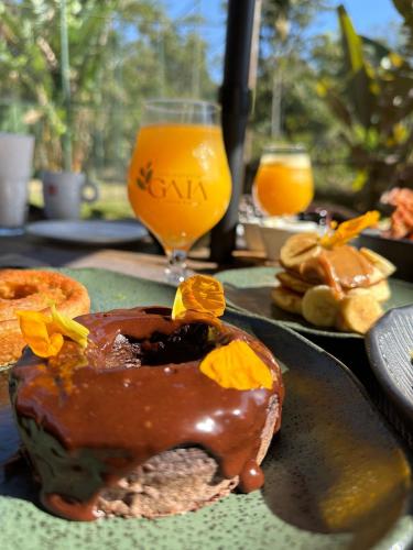 a plate with a chocolate dessert and a glass of orange juice at Gaia Hotelaria in Teresópolis