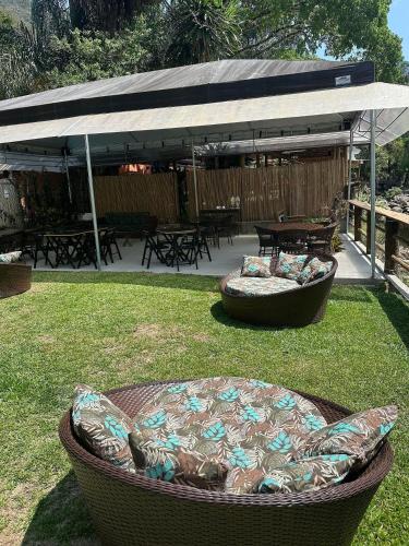 a patio with a large couch in the grass at Gaia Hotelaria in Teresópolis