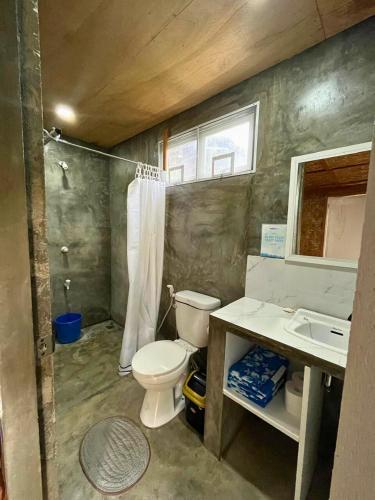 a small bathroom with a toilet and a sink at Bulkan Villa Rental in General Luna