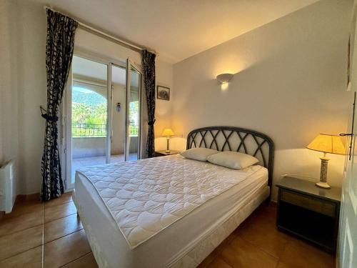 une chambre avec un grand lit et une fenêtre dans l'établissement Appartement 3 pièces avec terrasse à Cavalaire - FR-1-226B-220, à Cavalaire-sur-Mer
