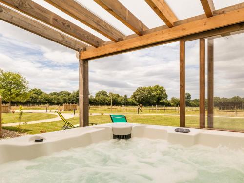 d'une baignoire devant une grande fenêtre. dans l'établissement Longère moderne avec spa, billard, babyfoot, salle de sport, hammam, et Wi-Fi - FR-1-306-1288, à La Chapelle-Saint-Sauveur