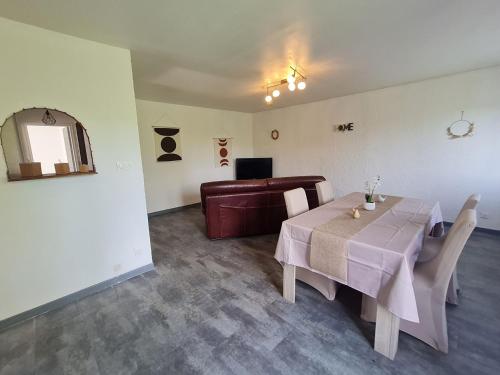 une salle à manger avec une table et un canapé dans l'établissement Gîte calme 3 chambres à Lunéville avec garage - FR-1-584-331, à Lunéville