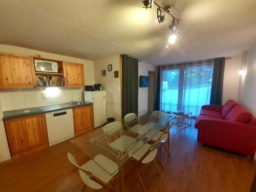 - un salon avec une table en verre et un canapé rouge dans l'établissement Appartement cosy 8 pers avec coin nuit, terrasse et WiFi à Valfréjus - FR-1-561-123, à Modane