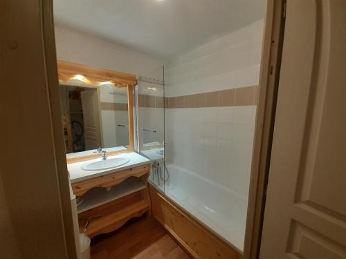 une salle de bain avec un lavabo, une baignoire et un miroir dans l'établissement Appartement cosy 8 pers avec coin nuit, terrasse et WiFi à Valfréjus - FR-1-561-123, à Modane