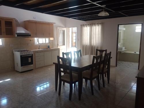 a kitchen with a dining room table and chairs at Morada Romana in Rivadavia