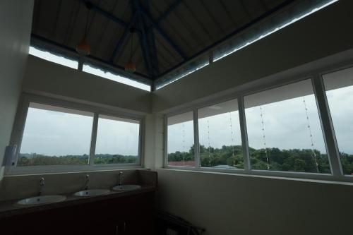 a bathroom with three sinks and a row of windows at Swami Prasad Paradise hotel in Golitattu