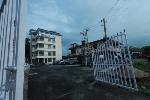 a gate in a parking lot next to a building at Swami Prasad Paradise hotel in Golitattu