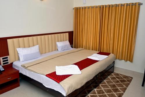 a bedroom with a bed with two towels on it at Swami Prasad Paradise hotel in Golitattu