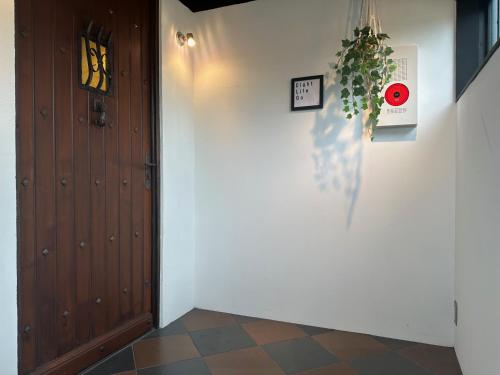 a hallway with a wooden door and a tile floor at Eight Life Go-173ｍ2超の1棟貸し in Hayama