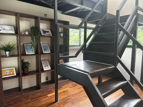 a black spiral staircase in a room with a book shelf at Eight Life Go-173ｍ2超の1棟貸し in Hayama