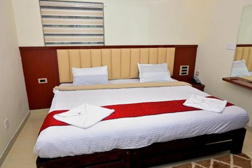 a bedroom with a large bed with a red blanket at Swami Prasad Paradise hotel in Golitattu