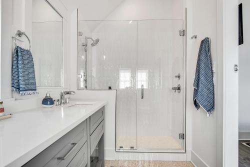 a white bathroom with a shower and a sink at Isle of Dogs 205FIV-B in Port Aransas