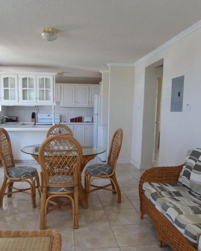 Una cocina y un comedor con mesa y sillas. en Ocean Path Villas, en Christ Church