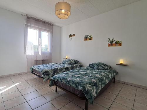 une chambre avec deux lits et une fenêtre dans l'établissement Gîte calme 3 chambres à Lunéville avec garage - FR-1-584-331, à Lunéville