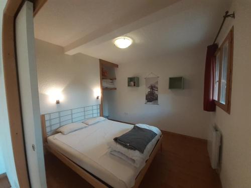 une petite chambre avec un lit dans une pièce dans l'établissement Appartement 4 pers avec Wi-Fi et Animaux admis proche remontées à Valfréjus - FR-1-561-122, à Modane