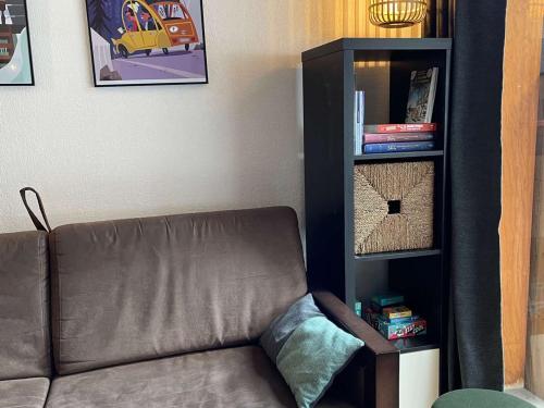 un salon avec un canapé et une étagère dans l'établissement App. skis aux pieds avec piscine, balcon et WiFi - FR-1-322-646, aux Orres