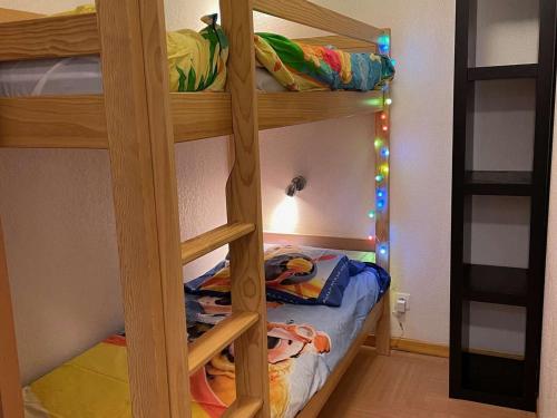 - un lit superposé pour enfants avec une échelle dans l'établissement App. skis aux pieds avec piscine, balcon et WiFi - FR-1-322-646, aux Orres