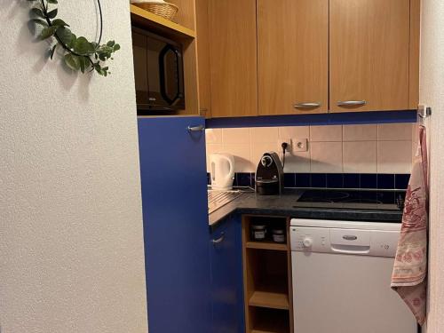 - une cuisine avec des armoires bleues et un réfrigérateur bleu dans l'établissement App. skis aux pieds avec piscine, balcon et WiFi - FR-1-322-646, aux Orres