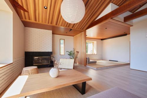 a living room with a fireplace and a wooden ceiling at プライベートリゾート南風 in Higashiizu