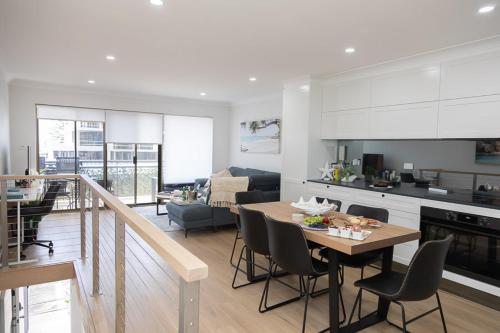 a kitchen and living room with a table and chairs at Joy's Hideaway in Terrigal