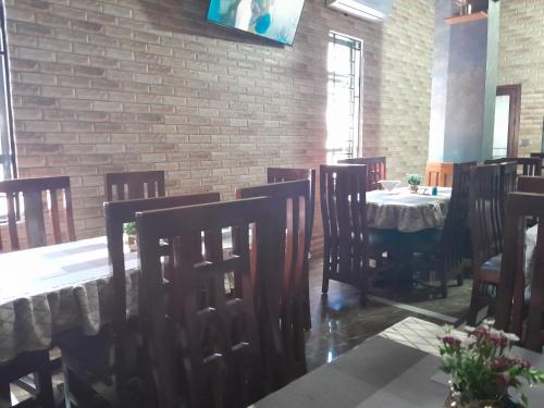a dining room with a table and chairs and a brick wall at Mazola Diamond Hotel in Dar es Salaam