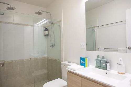 a bathroom with a shower and a toilet and a sink at Joy's Hideaway in Terrigal