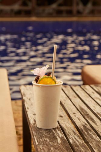 a drink in a cup sitting on a table next to a pool at Hotel Reserva de Piedemonte in Villavicencio