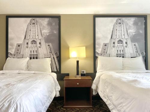 a hotel room with two beds and a picture of two towers at Super 8 by Wyndham Greensburg in Greensburg