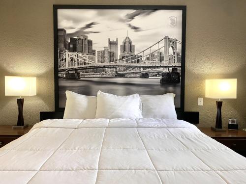 a bedroom with a large white bed and a bridge at Super 8 by Wyndham Greensburg in Greensburg