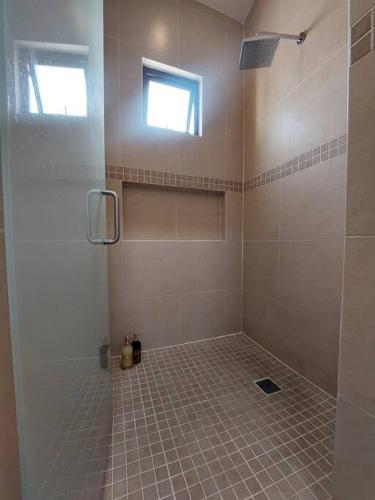 a bathroom with a shower with a tiled floor and a window at Encantadora Casa en La Yesca cerca de poliforum in Santa Julia