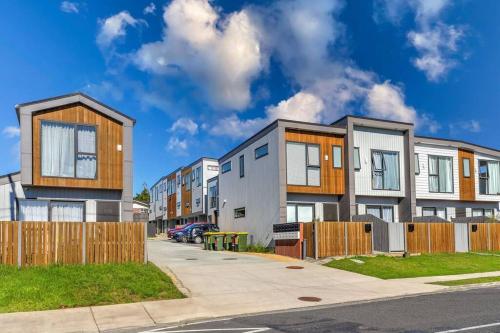 a row of houses on a street with a fence at Townhouse in New Lynn in Auckland