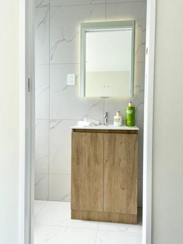 a bathroom with a sink and a mirror at Townhouse in New Lynn in Auckland